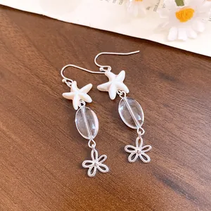 Close-up of beach style starfish and glass bead drop earrings with flower charm details