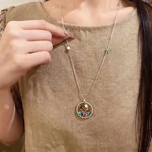 Elegant beaded round hollow pendant necklace for women on a beige textured top