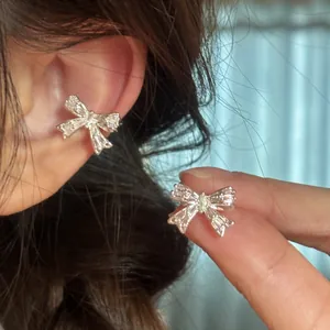 Vue macro détaillée d'un clip d'oreille nœud en argent avec des zircons sur l'oreille