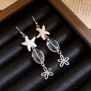 Macro detail of starfish and flower dangle earrings with clear glass beads