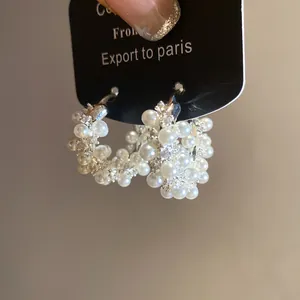 Close-up of elegant hoop earrings with white pearls and sparkling cubic zirconia stones
