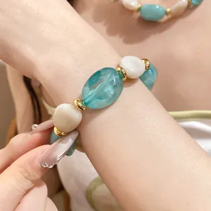 Detailansicht eines modischen Perlenarmbands aus Acryl in Blau und Weiß am Handgelenk