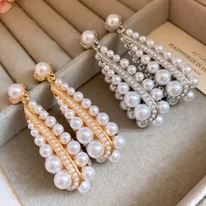 Detailed view of vintage style pearl drop earrings in gold and silver plating