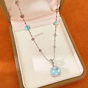 Detailed macro shot of silver necklace featuring a light blue square pendant in jewelry box