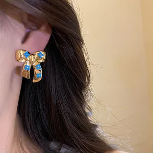 Vintage style gold bow stud earrings featuring delicate blue zircon flower details for women