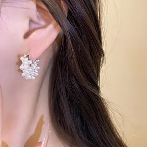 Close-up of elegant 18k gold plated hoop earrings with clusters of pearls and zircons