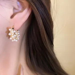 Close-up detail of elegant 18k gold plated hoop earrings with pearls and zircons