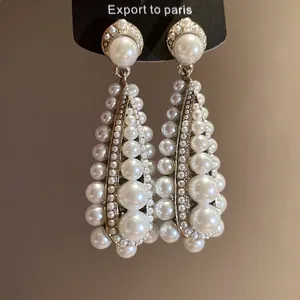 Vintage pear drop earrings with white pearls in multiple sizes on black display card