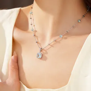 Close-up of elegant square light blue zircon necklace with glass beads worn by model