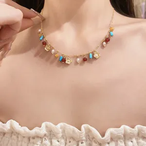 Macro view of a colorful stone beaded necklace with delicate gold hollow flower pendants
