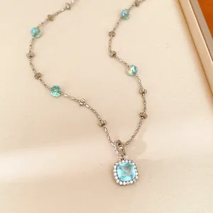 Detailed view of a square blue zircon pendant necklace with delicate beaded chain.