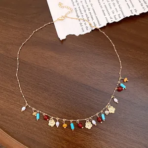 Detailed view of bohemian style necklace with colorful beads and gold flower charms.