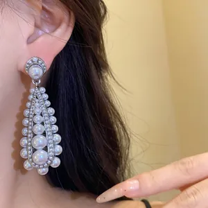 Detailed view of elegant vintage silver teardrop earrings featuring multi-sized white pearls