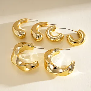 Vue macro d'un ensemble de six boucles d'oreilles créoles torsadées dorées avec tiges en acier