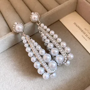 Close-up detail of vintage silver-tone teardrop earrings with elegant white pearls