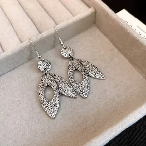 Close-up of vintage silver leaf dangle earrings with textured finish in jewelry box