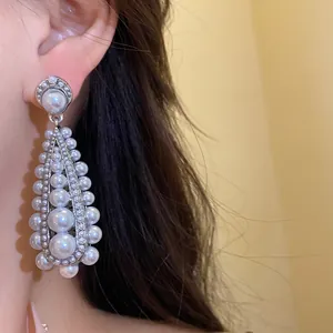 Detailed close-up view of vintage silver teardrop earrings with elegant white pearls