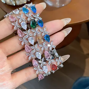 Close-up of elegant zircon bracelets with colorful teardrop stones and flower motifs.
