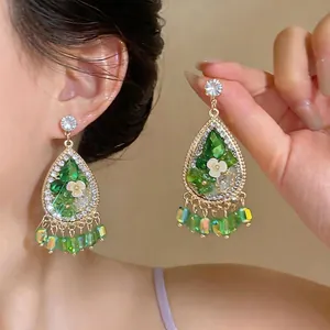 Vintage French style teardrop earrings featuring green crystals and delicate floral details