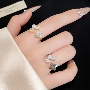 Eleganti anelli aperti con design floreale scintillante, zirconi e perle sulle dita
