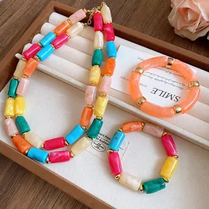 Colorful marbled acrylic cylindrical bead necklace and bracelets set on jewelry tray