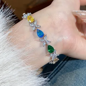 Detailed close-up view of a colorful zircon teardrop and flower bracelet worn on a wrist.