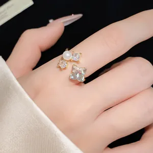 Dettaglio di un lussuoso anello aperto in oro con zircone a farfalla e perla tonda