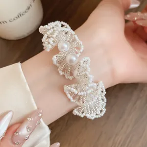 Détail exquis d'un bracelet en dentelle de perles de style français sur un poignet féminin