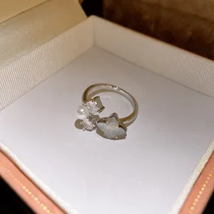 Primo piano di un anello aperto con zirconi e perle in una confezione regalo di lusso