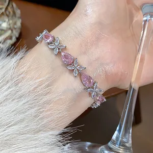 Detailed view of elegant pink pear-cut zircon and floral silver bracelet on wrist
