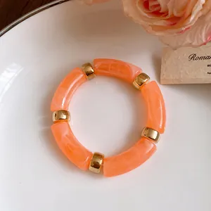 Detailed macro shot of sweet orange marbled acrylic cylindrical bead jewelry piece