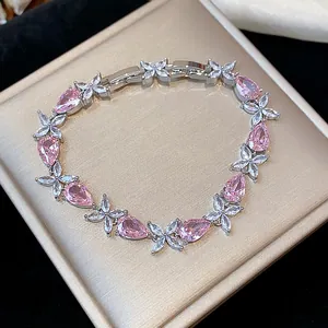 Detailed view of pink pear-shaped zircon and floral silver bracelet on gift box