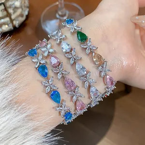 Detailed macro view of elegant flower and pear-cut colorful zircon bracelets on a woman's wrist