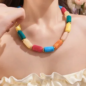 Close-up view of a colorful dopamine acrylic cylinder necklace worn by a female model