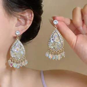Detailed close-up of ornate teardrop earrings with floral motifs and crystal accents.