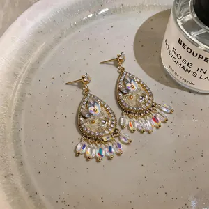 Detailed view of French palace style teardrop earrings with crystals and bead tassels
