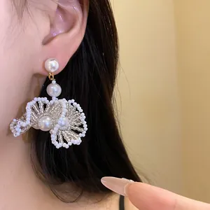 Vue détaillée de boucles d'oreilles pendantes en perles style français