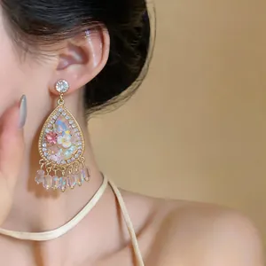 Close-up of elegant French palace style water-drop floral earrings with crystals on ear