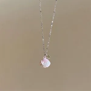 Close-up of a sweet Korean style stainless steel necklace with pink shell and green zircon pendant.