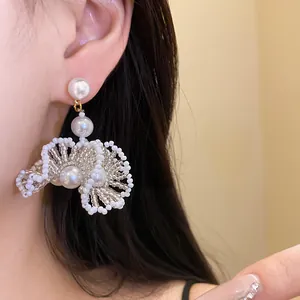 Détail rapproché de boucles d'oreilles en perles blanches de style français élégant