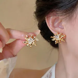 Detailed view of elegant gold flower stud earrings featuring sparkling zircon centers