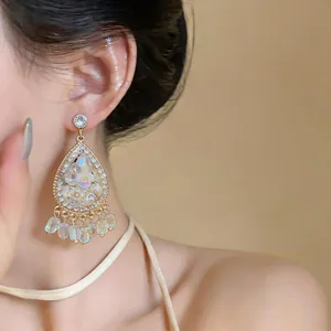 Detailed shot of French vintage water-drop earrings with carved flowers and rhinestones.