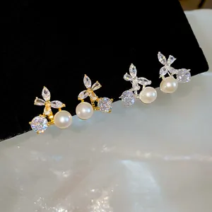 Detailed view of 18k gold plated butterfly earrings with sparkling zircons and pearls