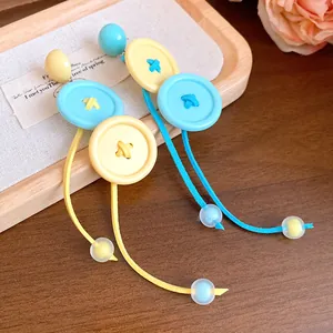 Vue macro détaillée des boucles d'oreilles boutons avec pompons et perles