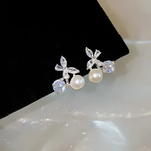Detailed close-up of 18k gold plated butterfly ear clips with pearls and cubic zirconia