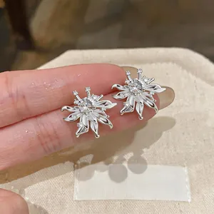 Close-up of elegant zircon flower stud earrings with detailed petal design and silver finish