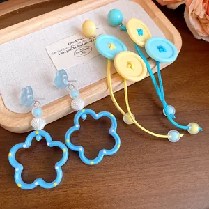 Gros plan détaillé de boucles d'oreilles fleur et gland en bouton couleur bonbon