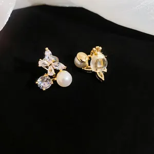 Close-up detail of 18k gold plated butterfly zirconia and pearl ear clips for non-pierced ears