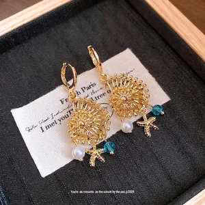 Pendientes colgantes dorados vintage con perla, cristal azul y dijes de estrella de mar