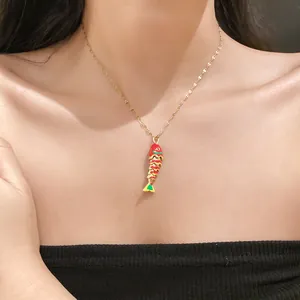 Detailed view of an elegant stainless steel fish pendant necklace with red enamel finish